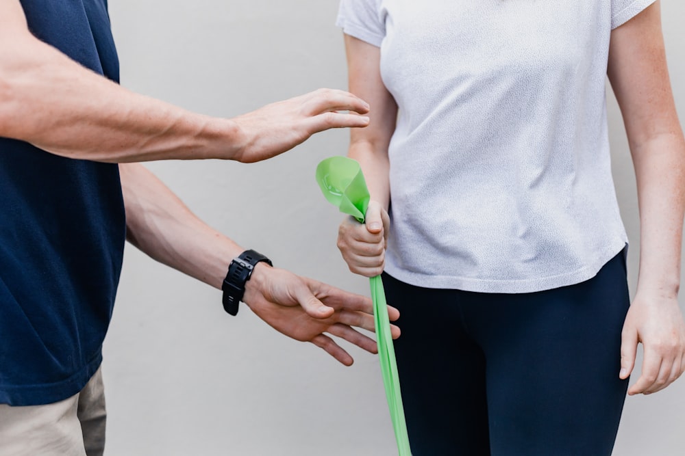 Fisioterapeuta orientando paciente no uso de faixa elástica para exercício terapêutico